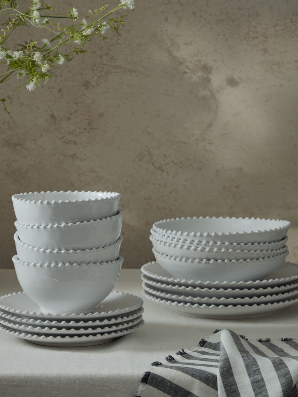 Person holding a stack of Vela Dinner Set