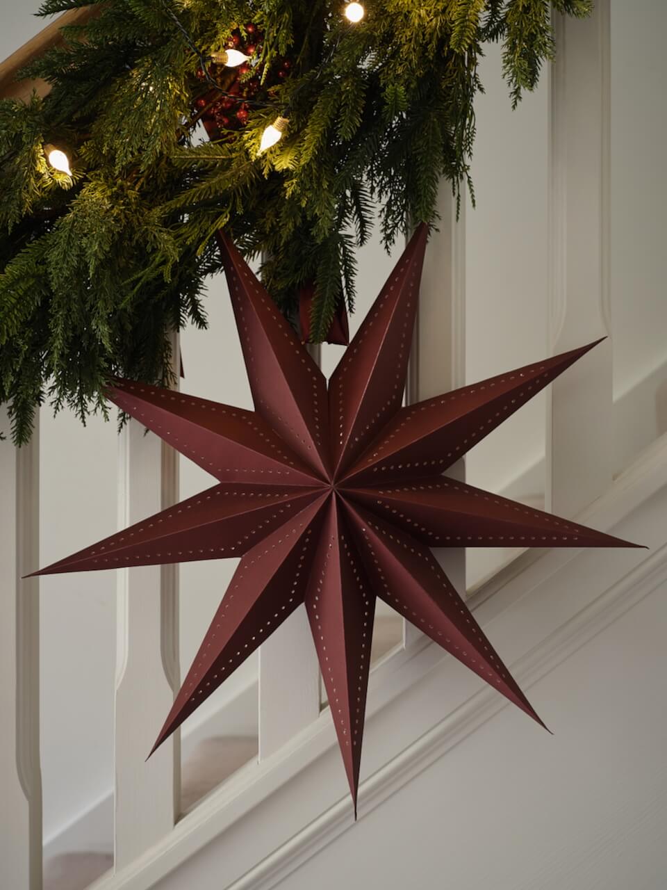 Burgundy Paper Star Decoration hanging on staircase.