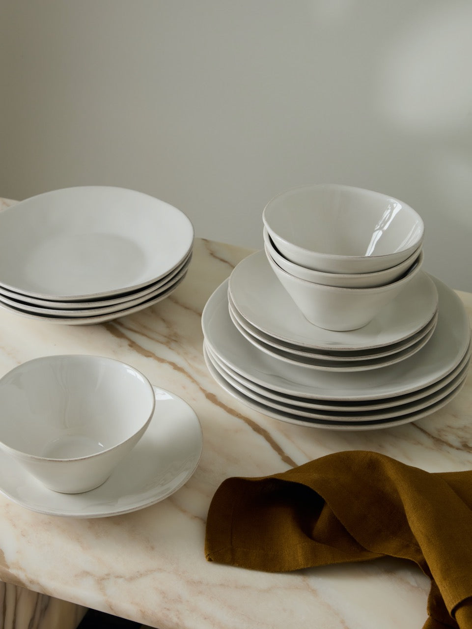 Portuguese stoneware plates and bowls from the Comporta collection styled on marble with linen napkin, neutral luxury tableware