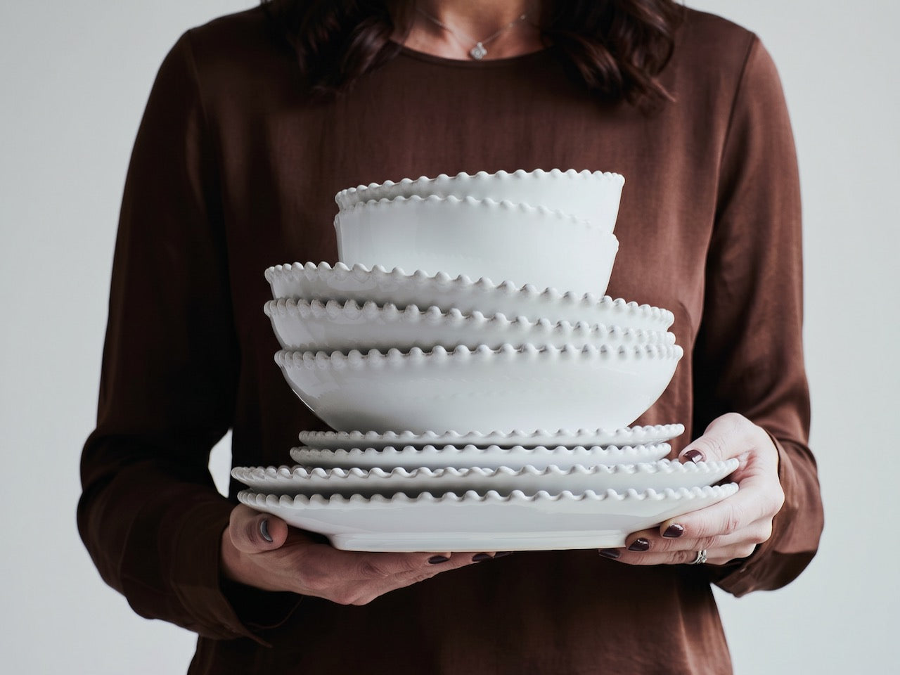 Handcrafted Portuguese stoneware dinnerware with pearl detailing, stacked plates and bowls in neutral styling, luxury tabletop
