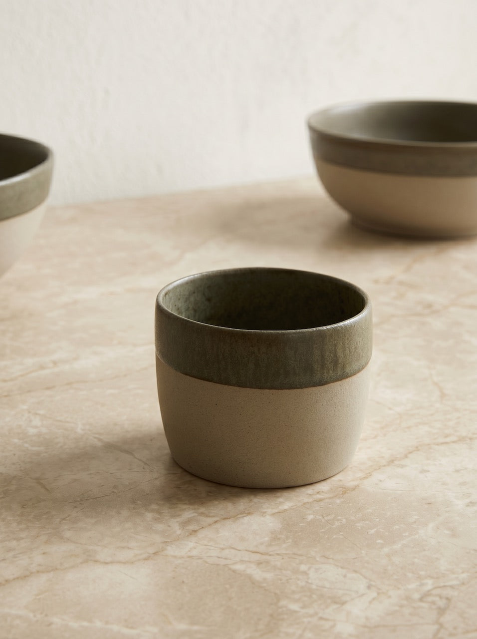 Set of ceramic bowls on a textured surface with a neutral background