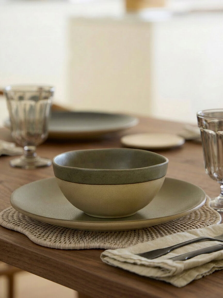 Ayre white scalloped rattan placemat styled with Arenito olive Portuguese stoneware on wooden dining table