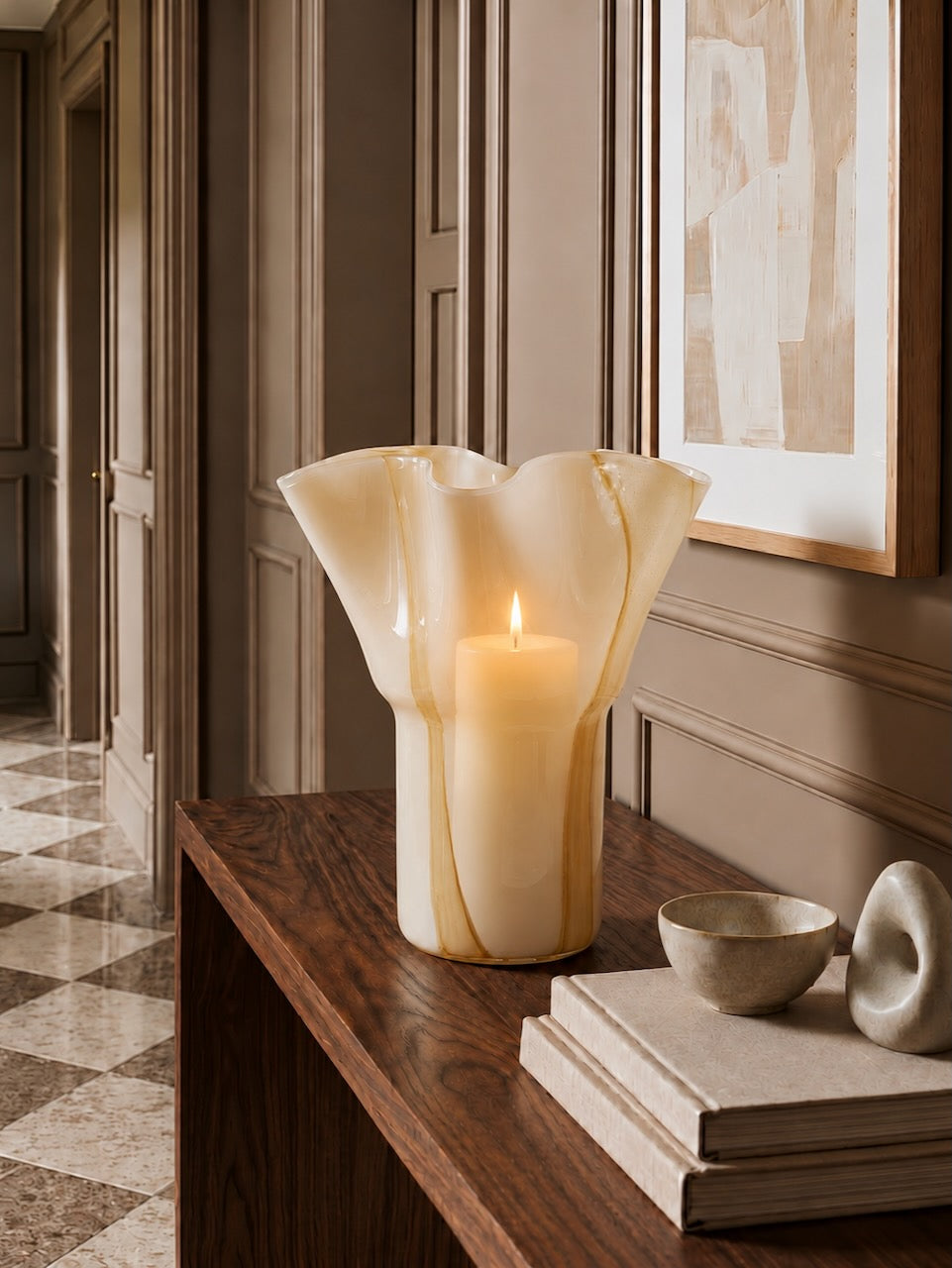 Decorative vase with a candle inside on a wooden surface in an elegant room.