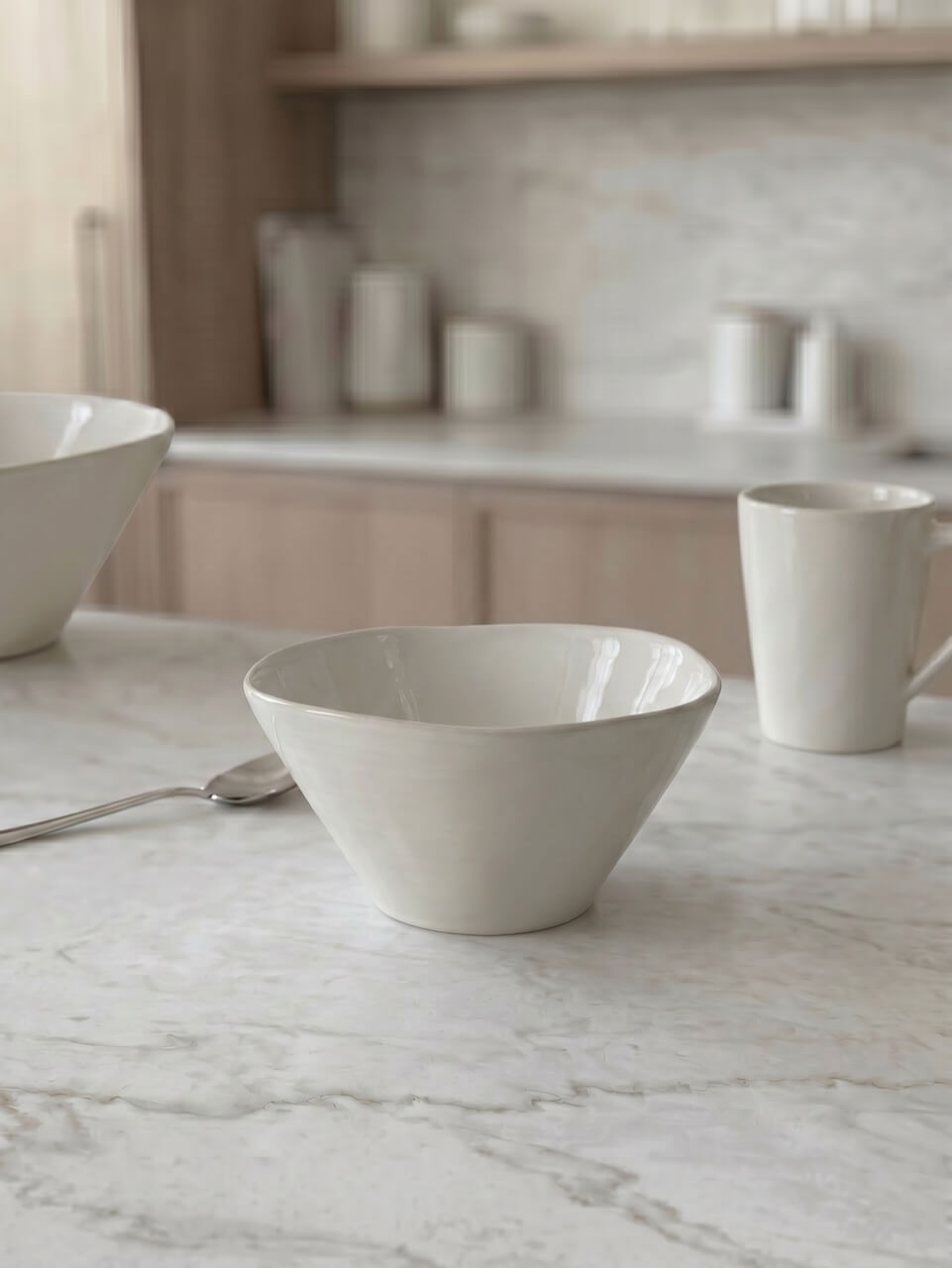 White ceramic bowl on a marble countertop with a neutral kitchen background