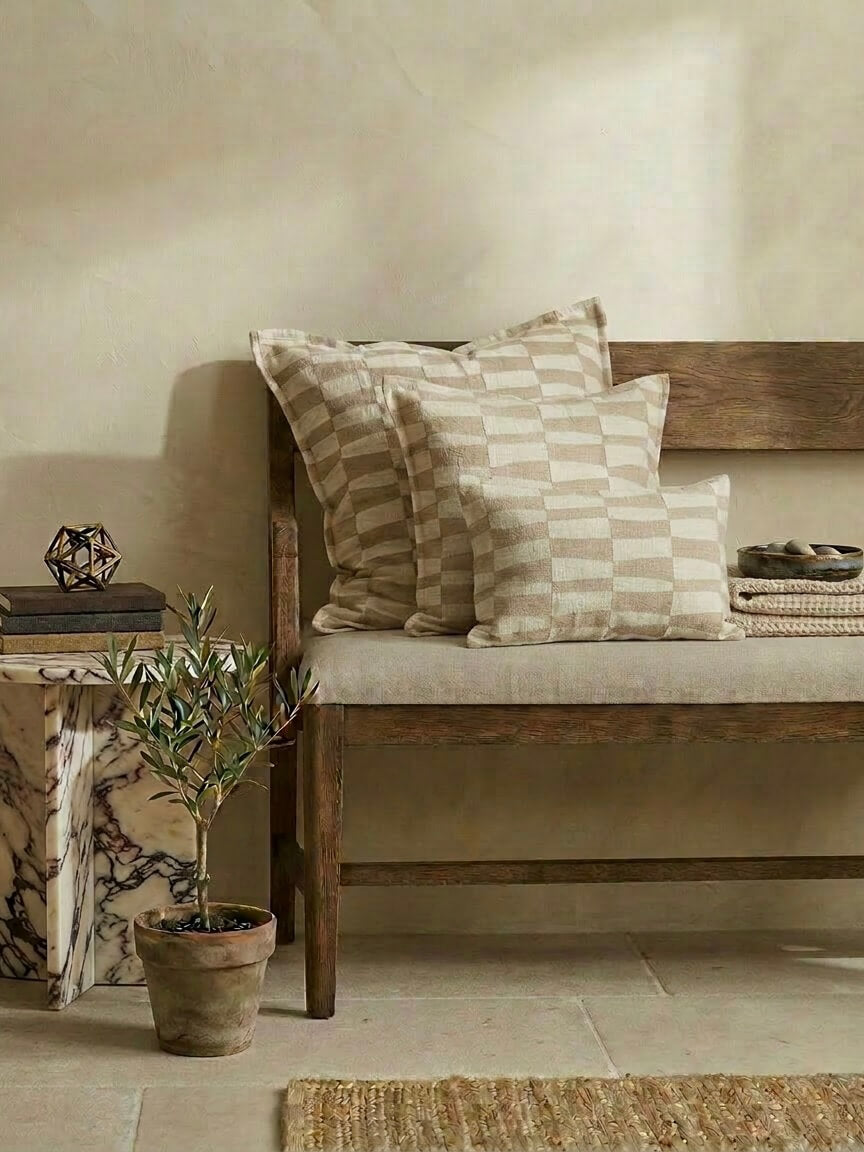 Set of caramel pattern cushion covers with a neutral checkered design on a wooden bench, styled with earthy decor and soft beige tones