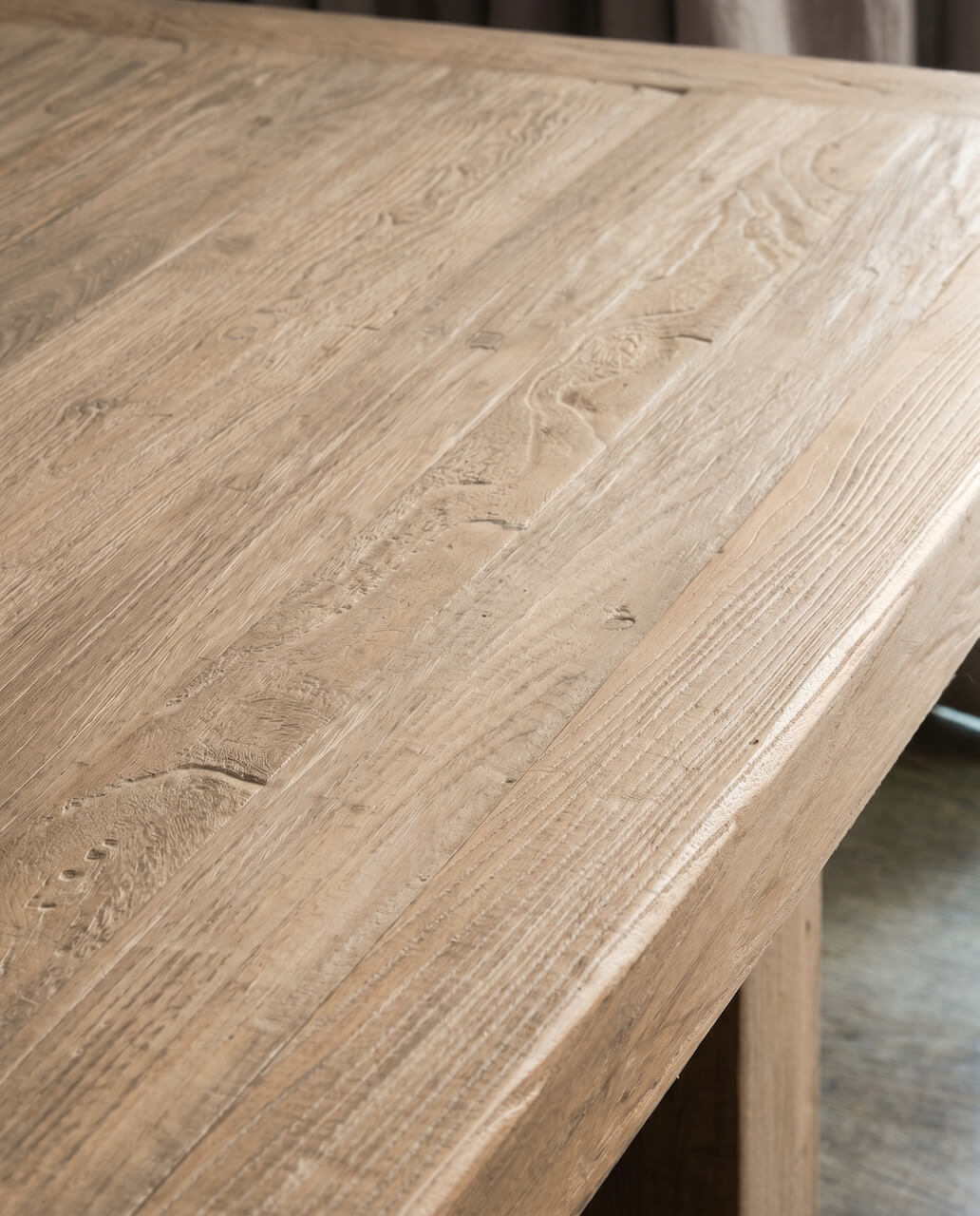 Close-up of a wooden table surface with visible grain and texture.