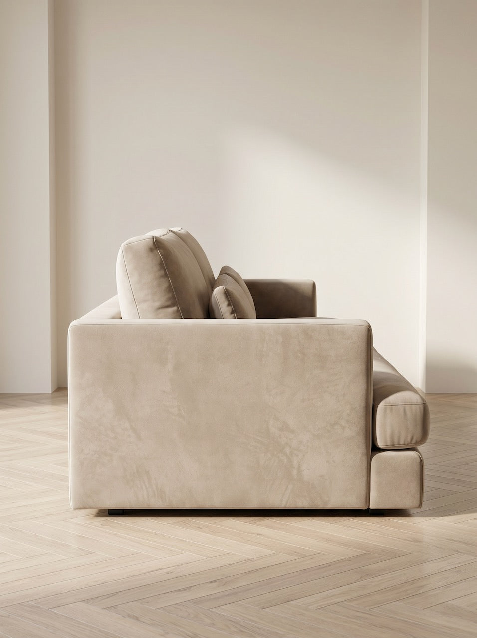 Beige sofa in a minimalistic room with wooden flooring and white walls